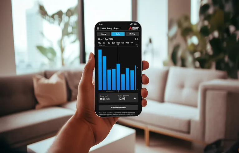 Hand holding a phone with the Mitsubishi Electric Energy Monitoring App on the screen